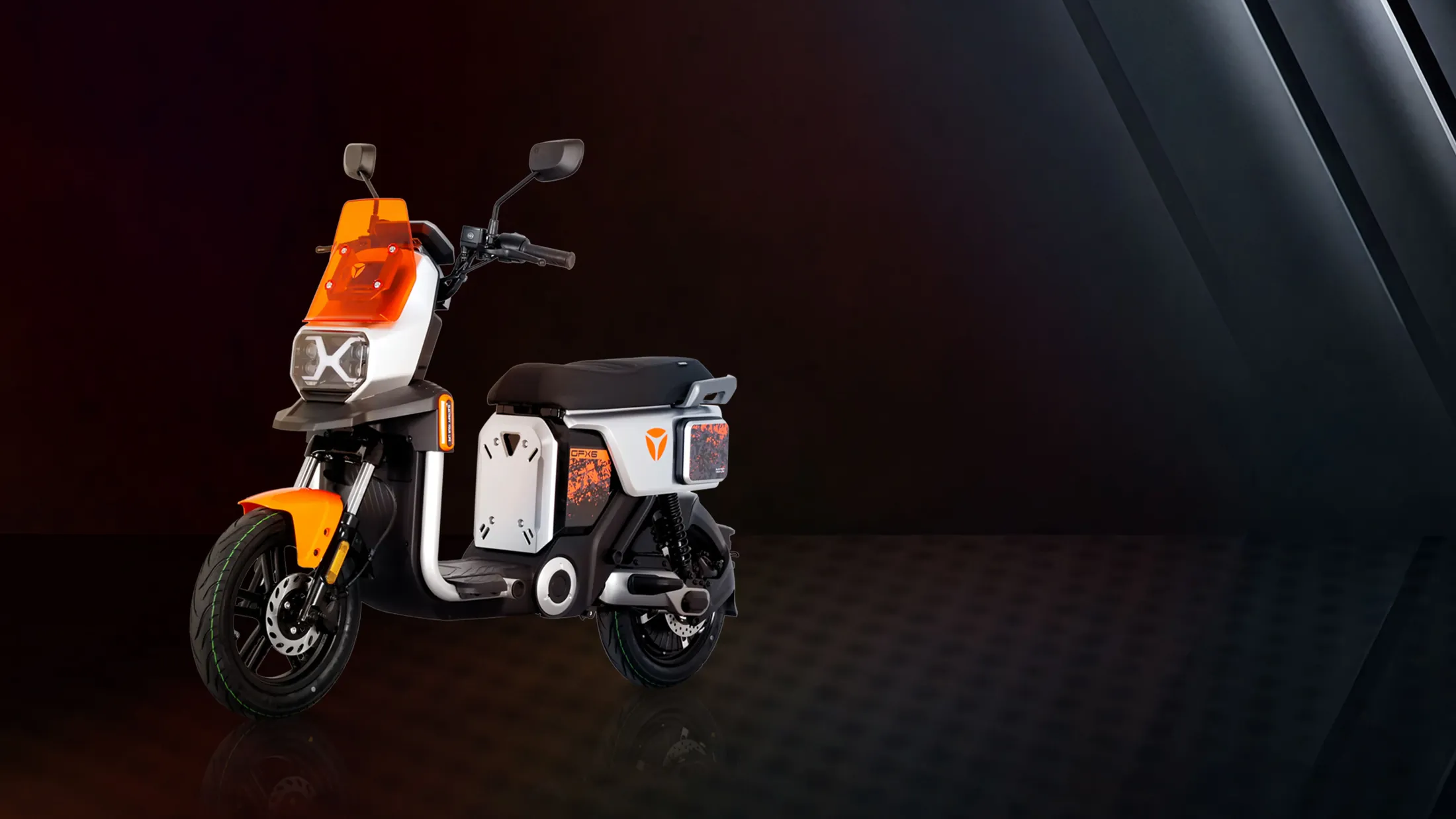 YADEA GFX6 orange et blanc, vue de trois quarts avant dans un studio sombre
