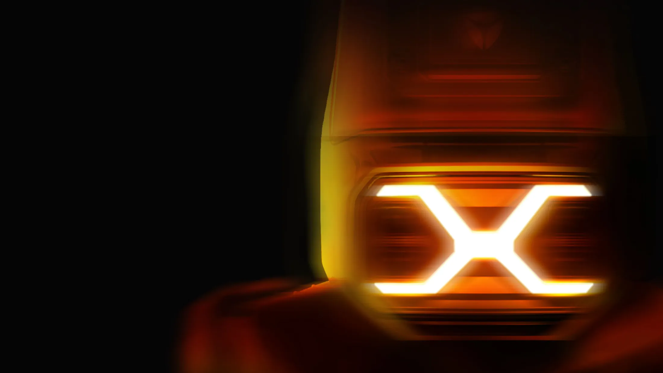 Feu arrière orange lumineux en forme de X dans l'obscurité